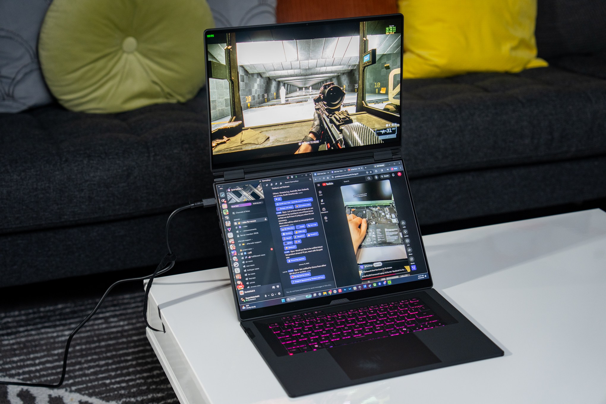 The Asus ROG Zephyrus Duo laptop on a table next to a couch.