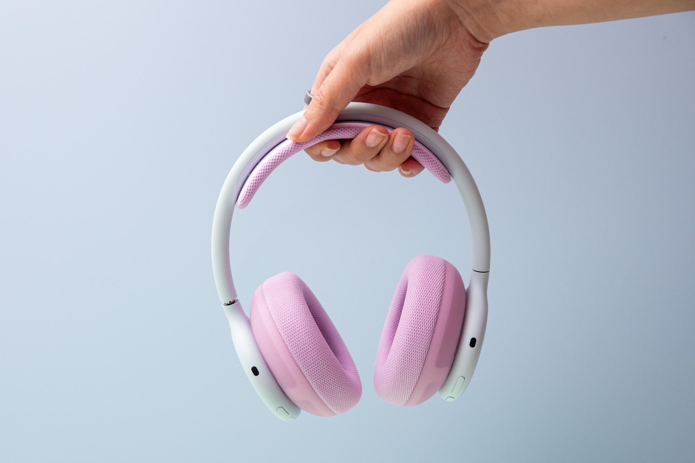 A hand holding the Beats 360 headphones.