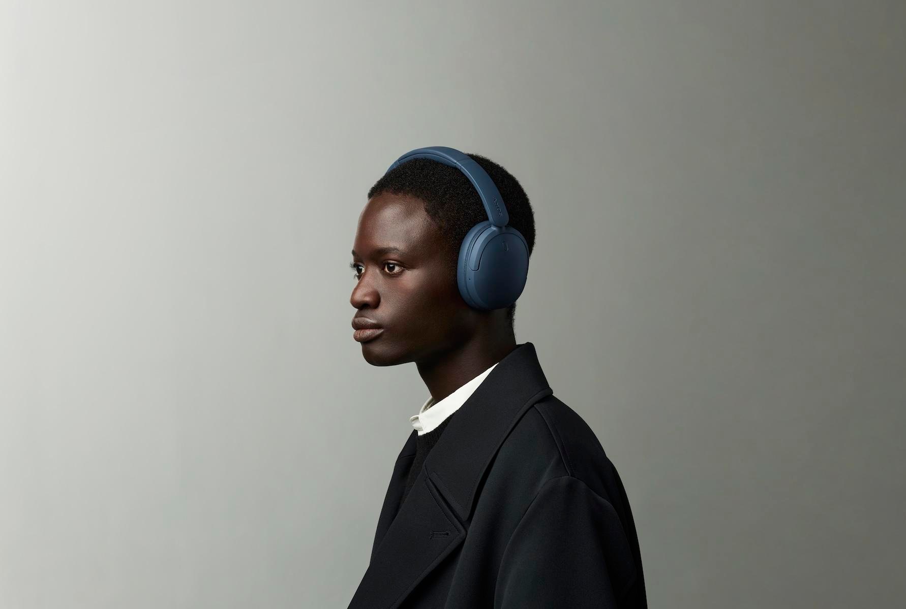 A person wearing the blue Sony WH-CH730N headphones.