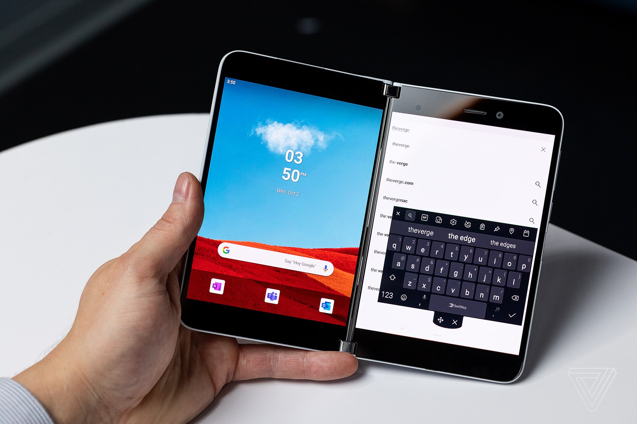 A person holding the Microsoft Surface Duo smartphone in one hand.